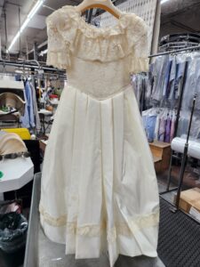 clean wedding gown on hanger at dry cleaner