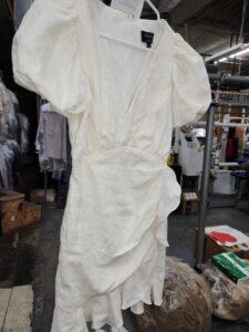 white dress on hanger at dry cleaners