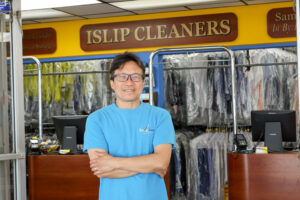 store owner in front of store sign